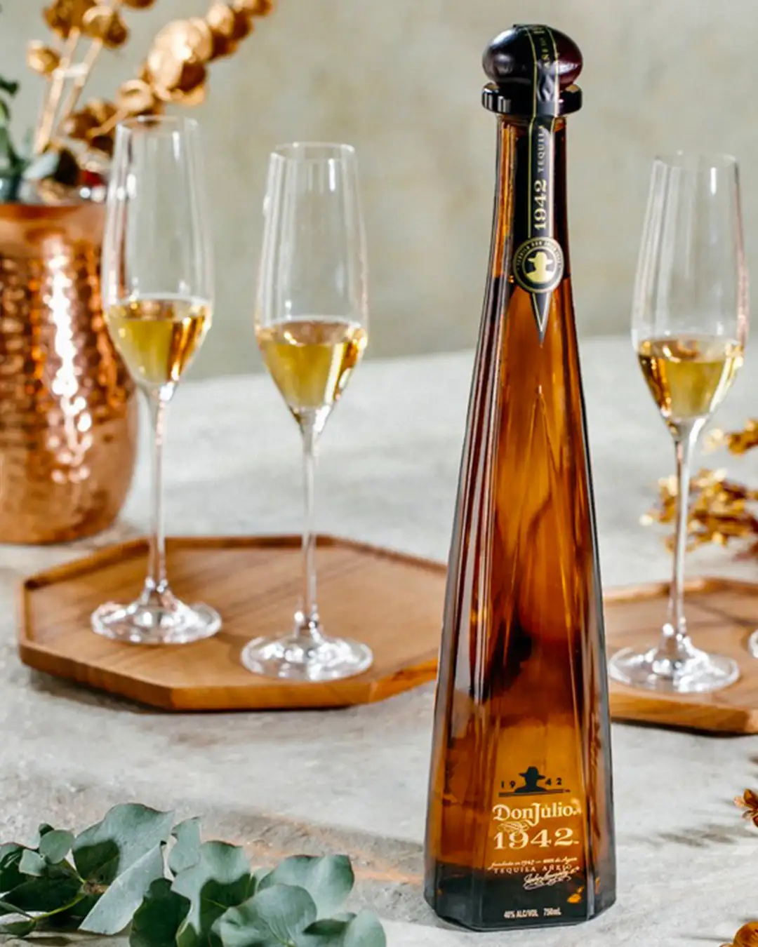 Don Julio 1942 Añejo Tequila – elegante Flasche mit 100 % Agave, präsentiert auf einem stilvoll gedeckten Tisch mit Champagnergläsern. Exklusiver Premium-Tequila für besondere Anlässe.